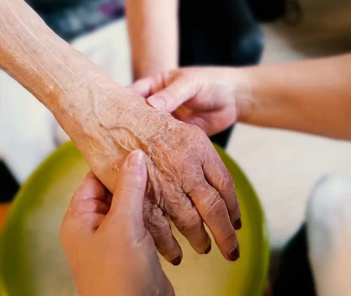 Handpflege für eine Bewohnerin im Altenheim